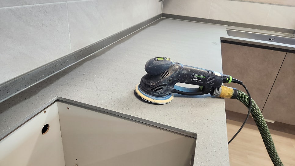 Festool 샌더로 진한 회색 카운터 연마